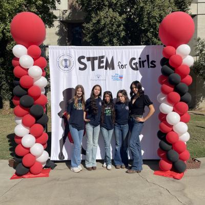 STEM for girls posing in front of banner