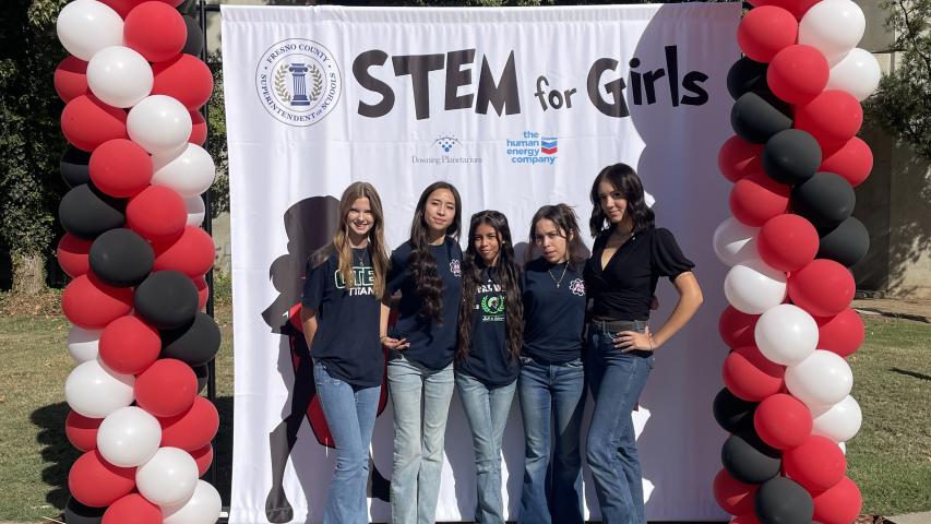 STEM for girls posing in front of banner